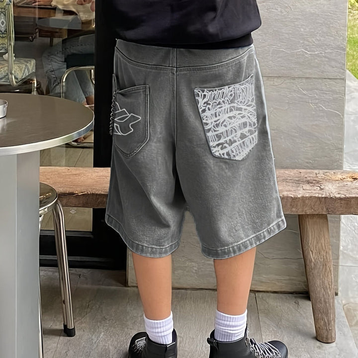 Trendy men's loose fit denim shorts, knee-length Bermuda style with fashionable floral embroidery.