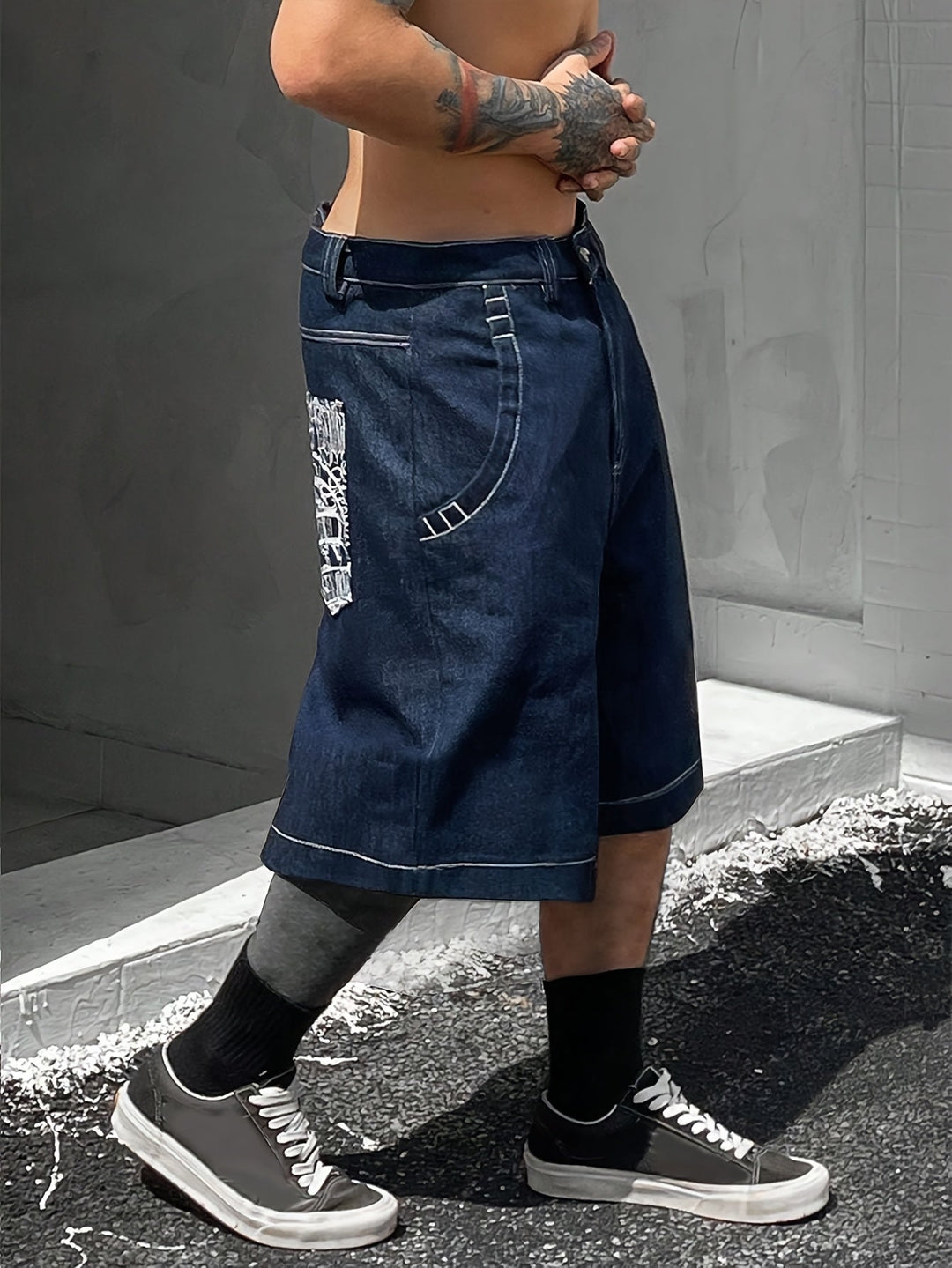 Front view of men's stylish loose fit Bermuda shorts, denim with unique floral embroidery.