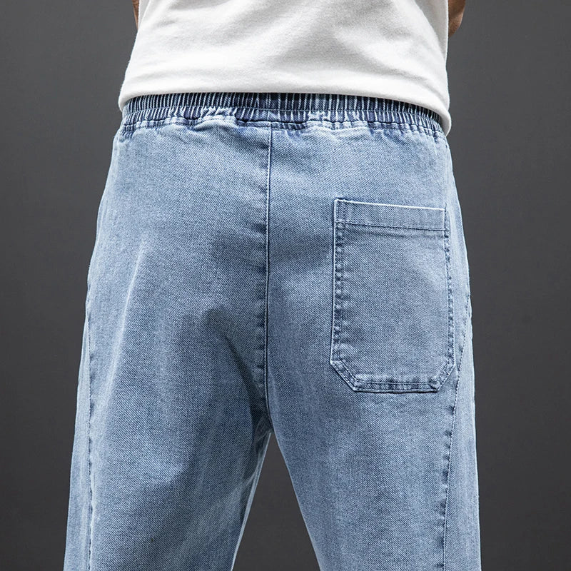 Close-up of men's jogger jeans featuring elastic drawstring waist and relaxed fit
