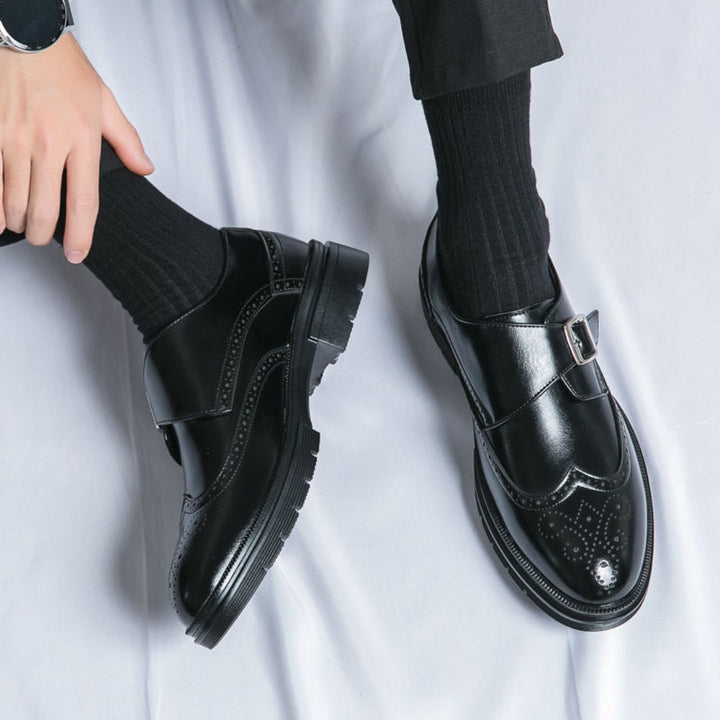 Close-up of men's leather monk strap wingtip brogue dress shoes showing detailed stitching and buckles.