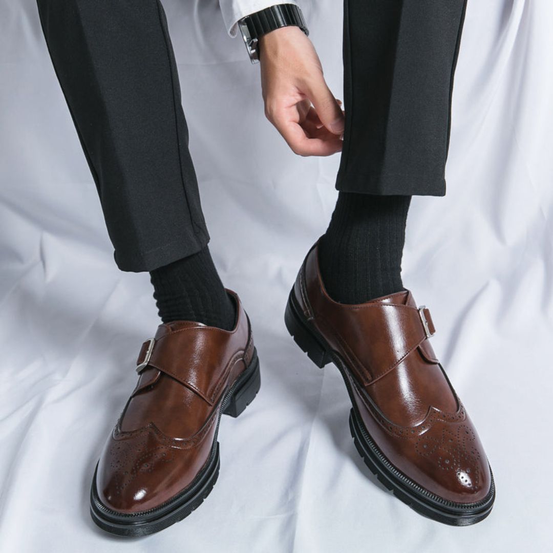 Elegant men's tan leather monk strap wingtip dress shoes featuring intricate brogue detailing for stylish outfits.