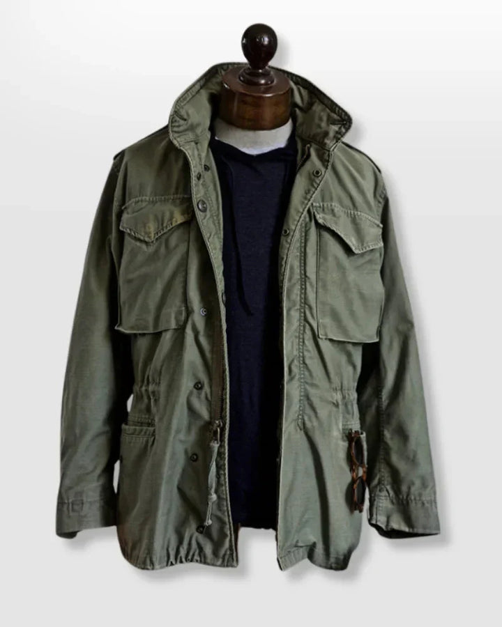 Close-up of a men's rugged vintage field jacket, highlighting adjustable waist and durable fabric.