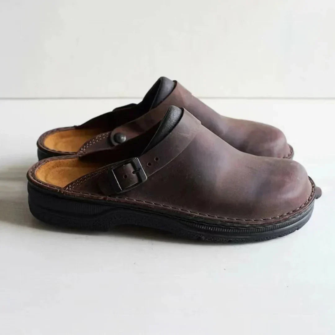 Relaxed men's comfort clogs with an adjustable buckle strap, providing everyday comfort. Durable slip-on footwear.