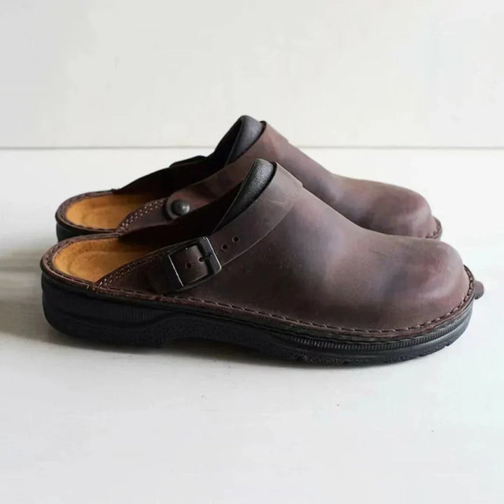 Relaxed men's comfort clogs with an adjustable buckle strap, providing everyday comfort. Durable slip-on footwear.