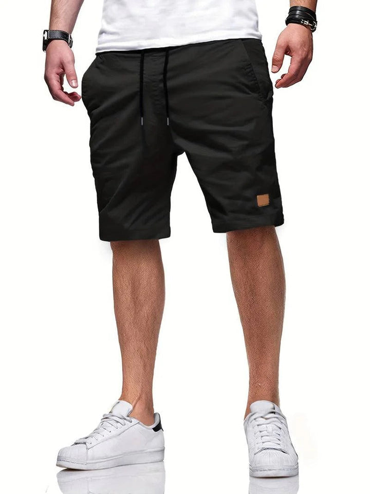 Man modeling relaxed fit drawstring shorts, ideal for summer casual everyday style.
