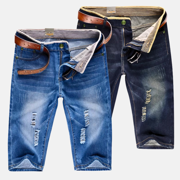Stylish men's distressed ripped streetwear shorts, knee-length for a rugged, casual summer fashion vibe.