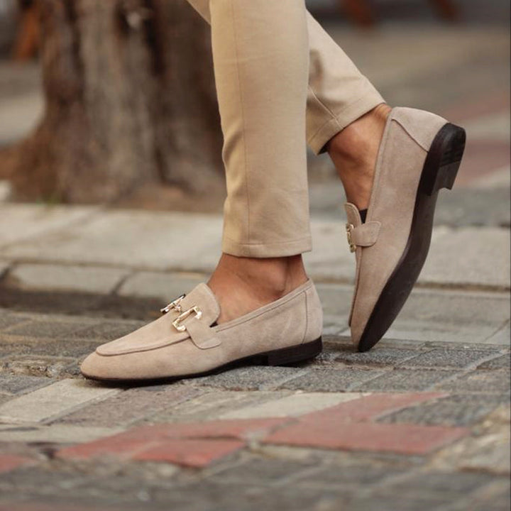 Close-up of a men's sophisticated brown leather horsebit loafer, highlighting the elegant metal detail and stitching.