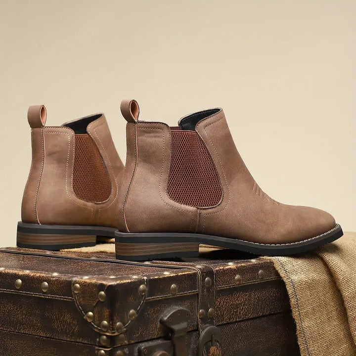 Stylish men's gray Chelsea boots with a subtle western flair, offering modern comfort & easy pull-on.