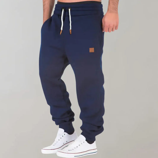 Men's heather gray cotton blend jogger pants with cuffed ankles, drawstring waist, and relaxed fit.