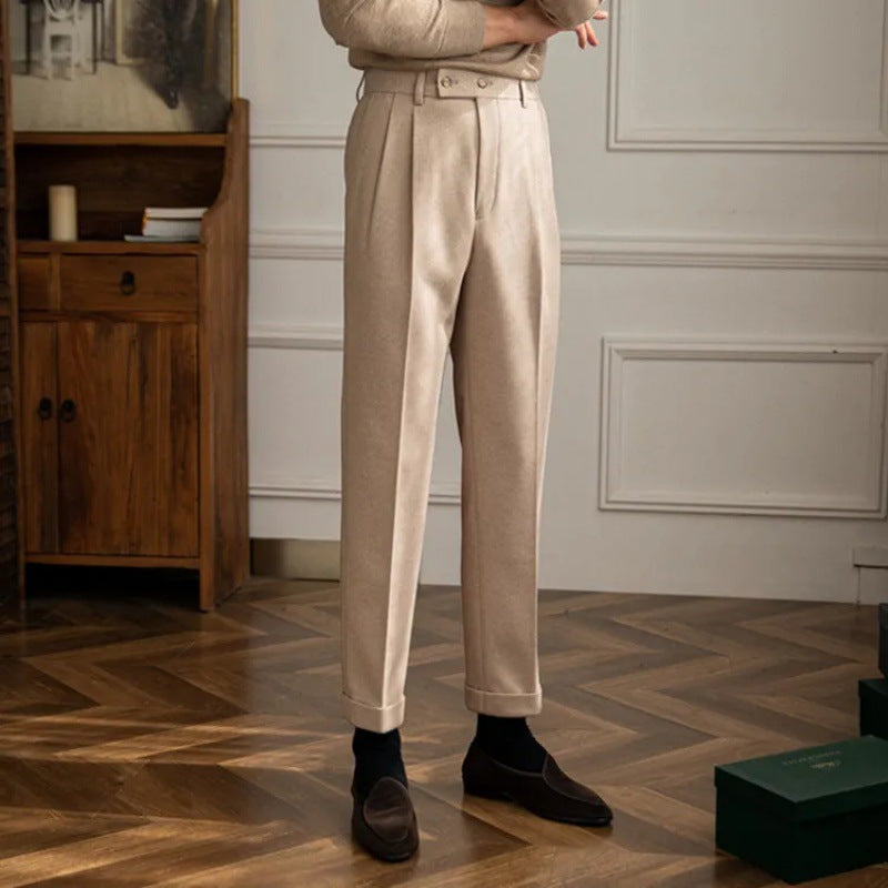 Stylish man wearing gray high-waisted pleated trousers, ideal for modern men's style.