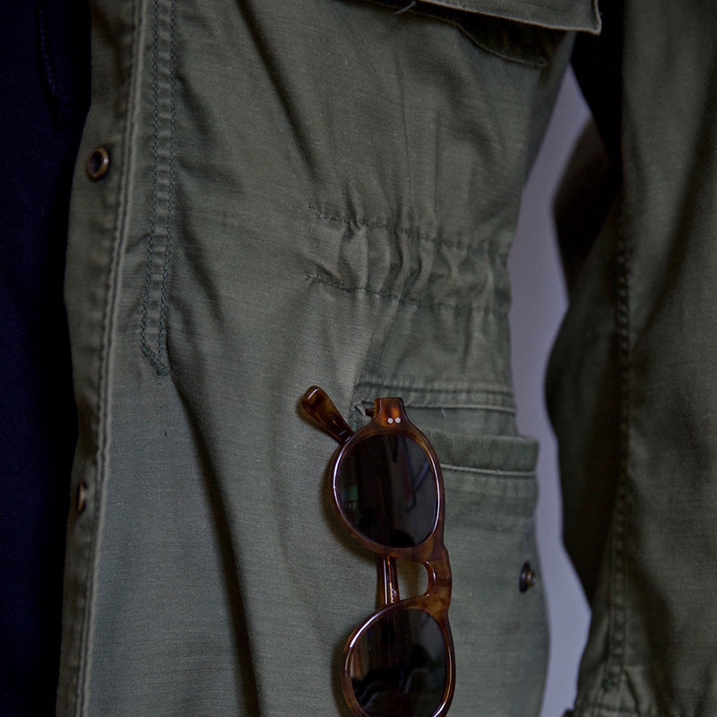 Green men's field jacket with a hood, ideal for outdoor wear and winter coat fashion.