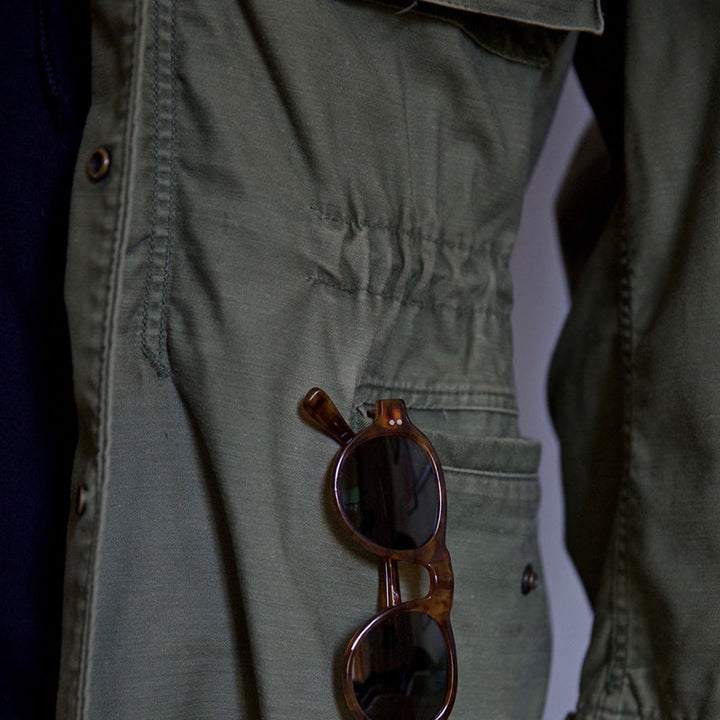 Green men's field jacket with a hood, ideal for outdoor wear and winter coat fashion.