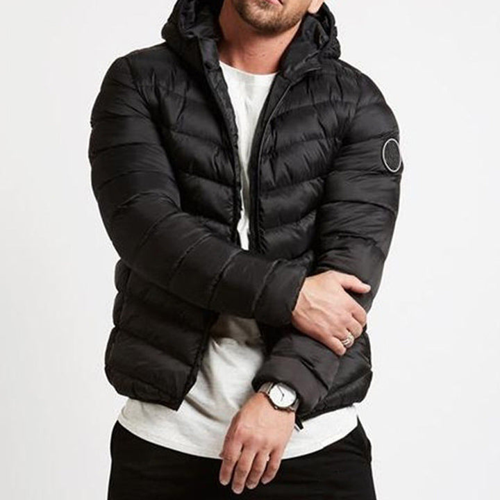 Urban men's casual hooded puffer jacket. Grey quilted winter outerwear for cold weather.