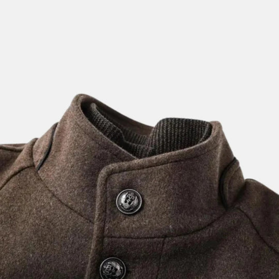 Brown men's mid-length overcoat with a sharp stand collar & button front, offering timeless style & warmth.