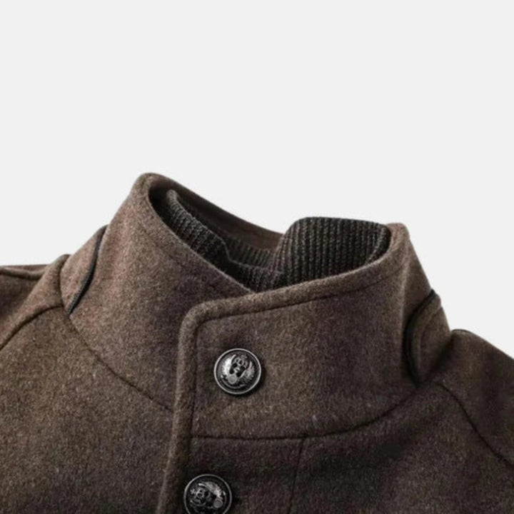Brown men's mid-length overcoat with a sharp stand collar & button front, offering timeless style & warmth.
