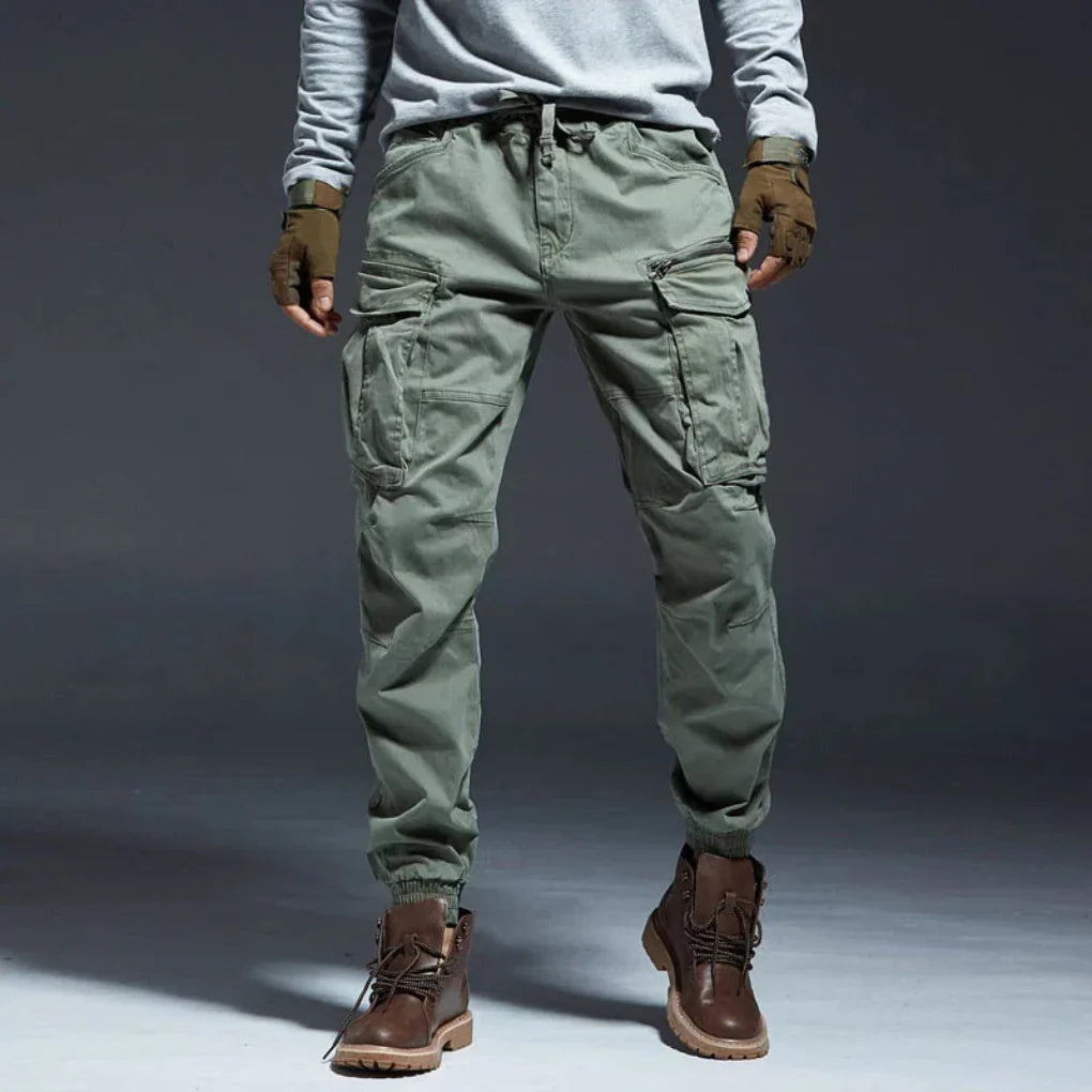 Green utility cargo pants for men, multi-pocket design ideal for outdoor adventures & travel.