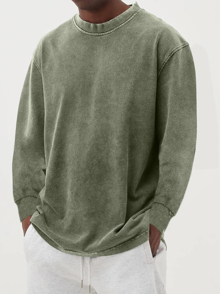 Man enjoying leisure in a stylish oversized crewneck sweater, embracing relaxed fit and casual comfort.