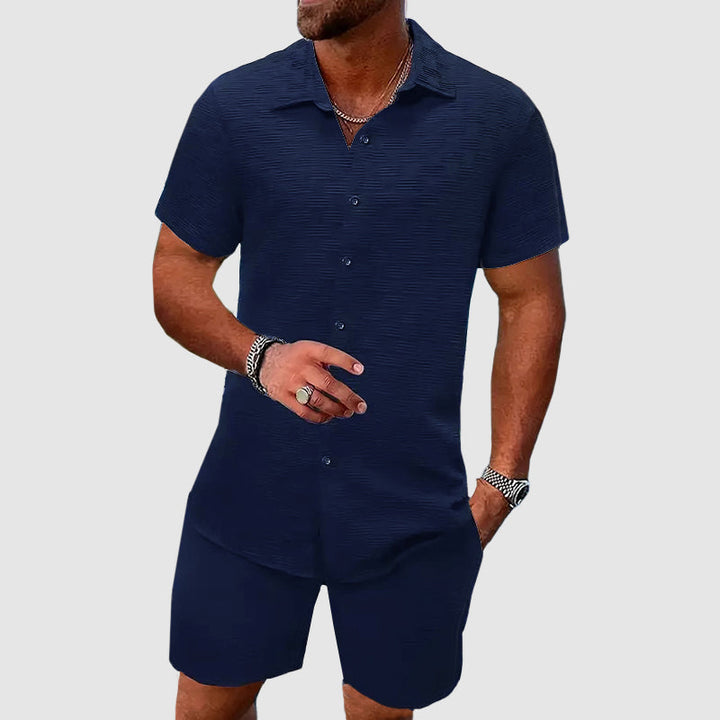 Stylish men's summer outfit: relaxed button-down shirt and comfortable shorts, ideal for beach wear.