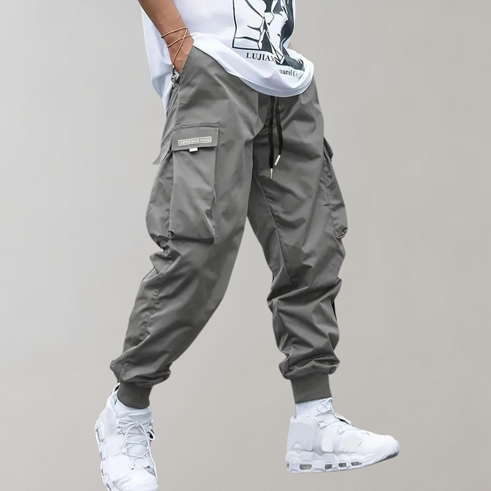 Detail shot: Men's relaxed fit cargo trousers showcasing drawstring waist & practical side utility pockets.