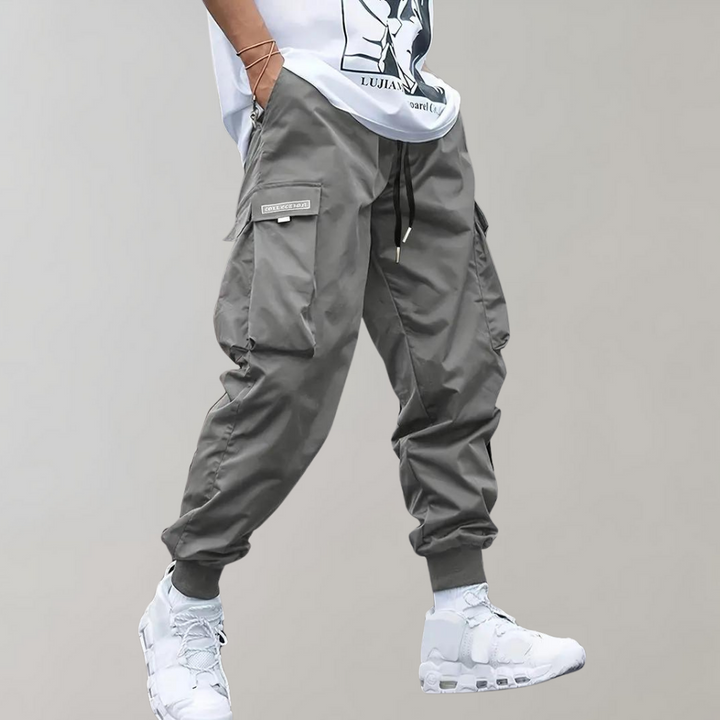 Detail shot: Men's relaxed fit cargo trousers showcasing drawstring waist & practical side utility pockets.