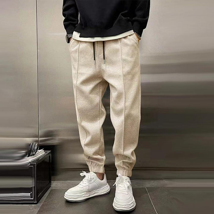 Men's relaxed fit casual trousers on a hanger, ready for wear, emphasizing easy-care and style