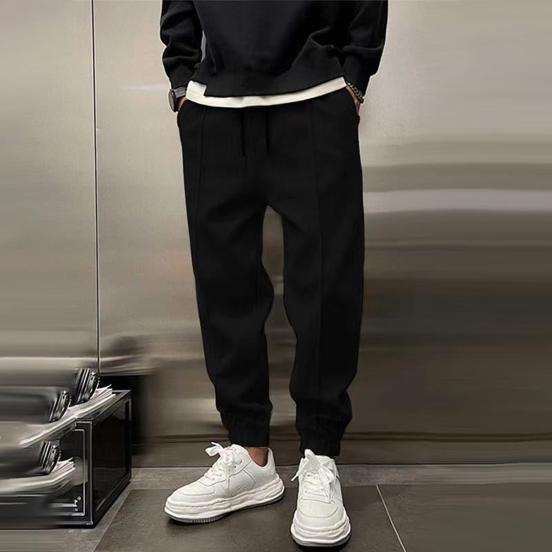 Man wearing men's relaxed fit casual trousers with a t-shirt, demonstrating a casual streetwear look