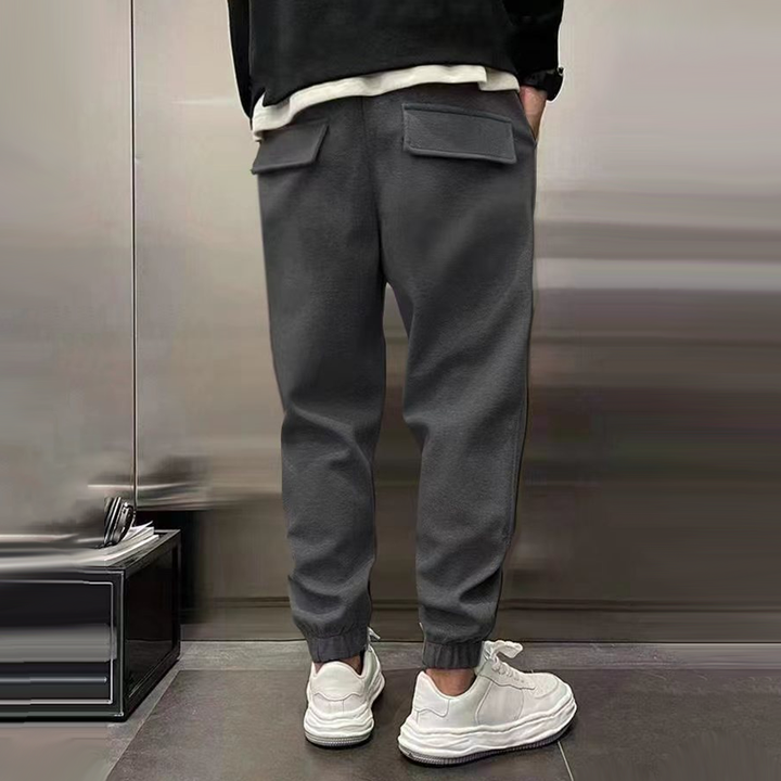 Men's relaxed fit casual trousers in grey paired with sneakers, ideal for a relaxed streetwear style