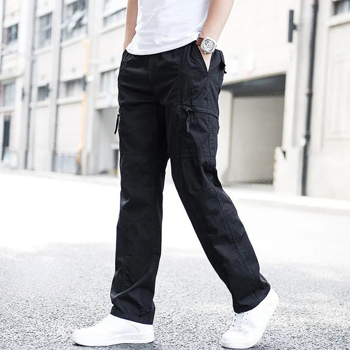 Close-up of black men's organic cotton cargo pants fabric and multi-pocket detail