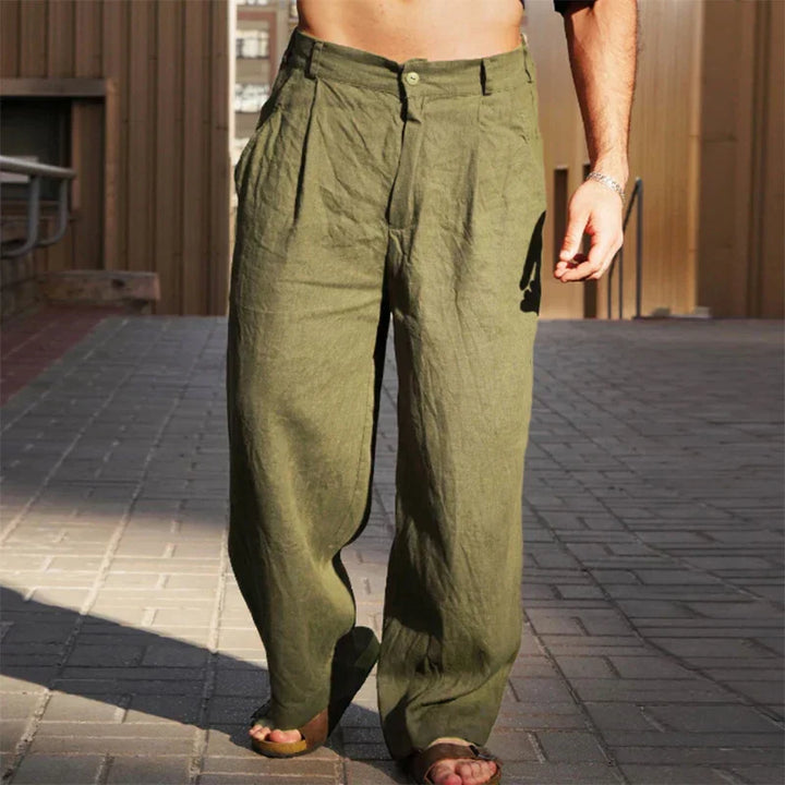 Detail shot of the pleats and waistband on men's relaxed fit linen pants.