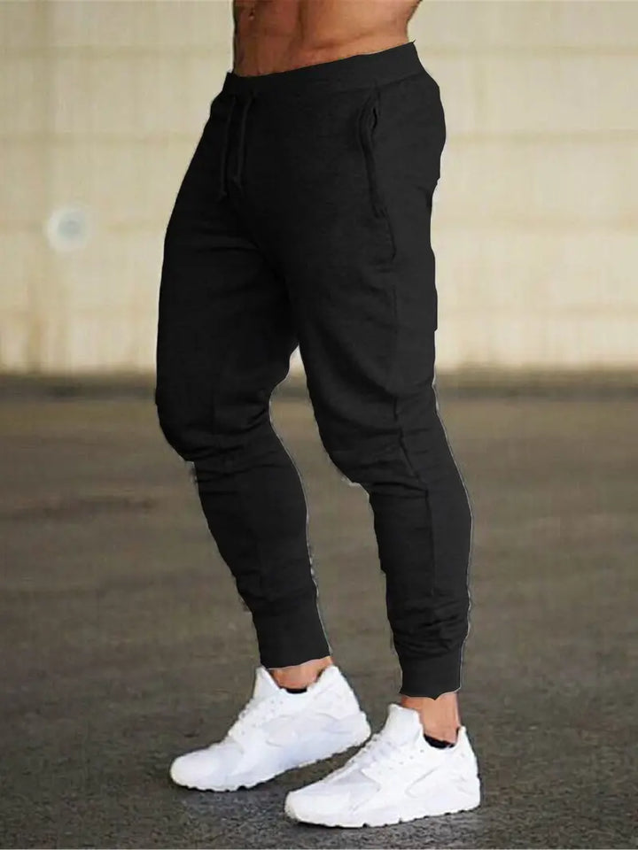 Athletic men's jogger pants, relaxed fit with tapered leg, shown in a studio shot, ideal for sports and comfort.