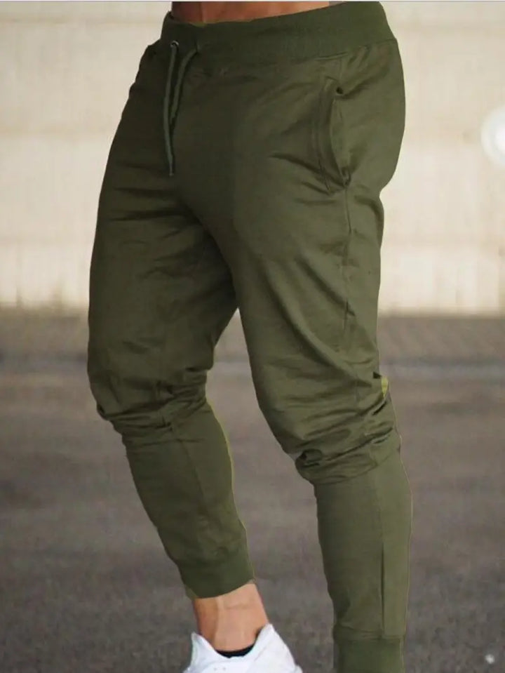 Close-up of the fabric texture and tapered leg detail on men's relaxed fit sports jogger pants, versatile activewear.