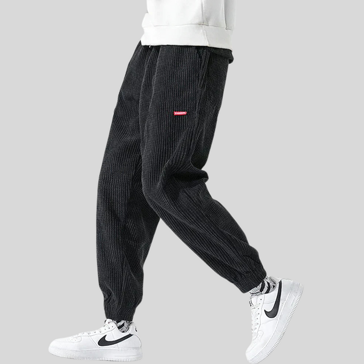 Black wide leg corduroy joggers for men, featuring a comfortable elastic waist.