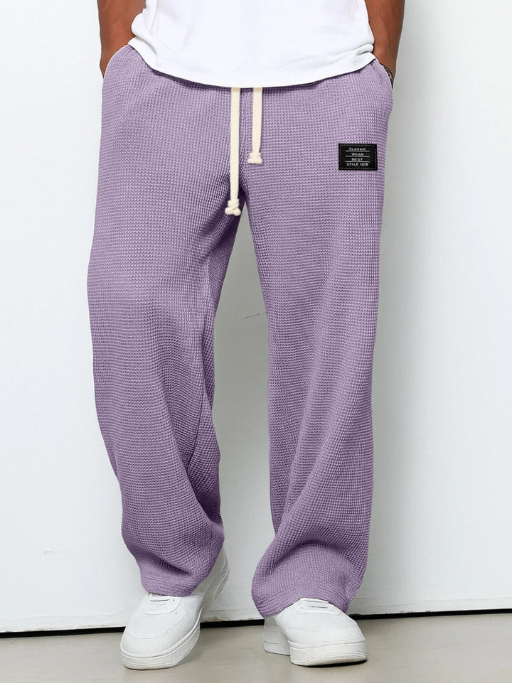 Folded men's wide leg sweatpants, highlighting the soft durable fabric for loungewear