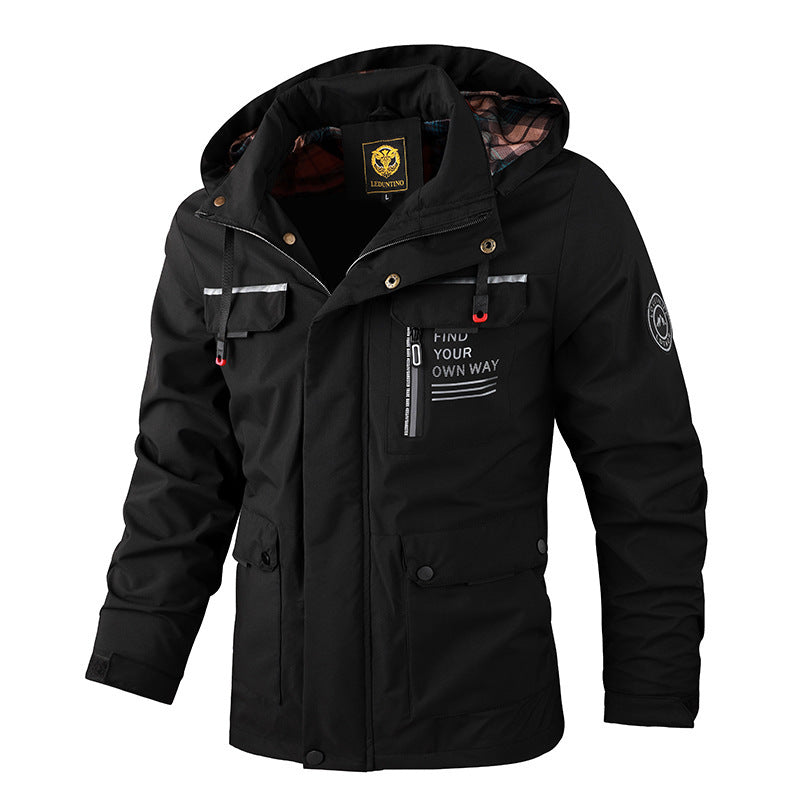 Lifestyle shot of a man wearing a black rugged all-weather outdoor jacket in a snowy landscape.