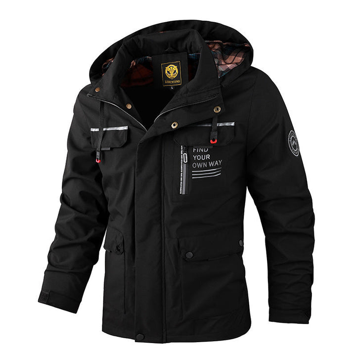 Lifestyle shot of a man wearing a black rugged all-weather outdoor jacket in a snowy landscape.