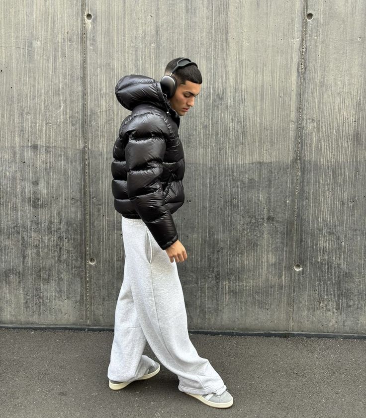 Side view of a men's shiny puffer jacket with hood, showcasing trendy street style outerwear.