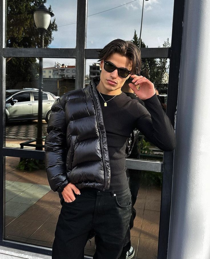 Close-up of fabric on a men's shiny puffer jacket with hood, highlighting its contemporary look.
