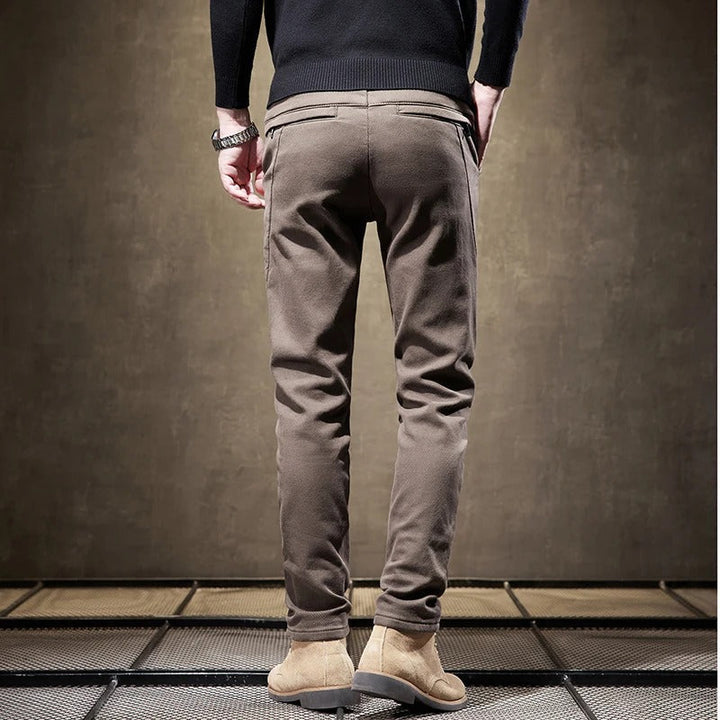 Detail of the button and zipper closure on men's slim-fit casual chino pants, enhancing style.
