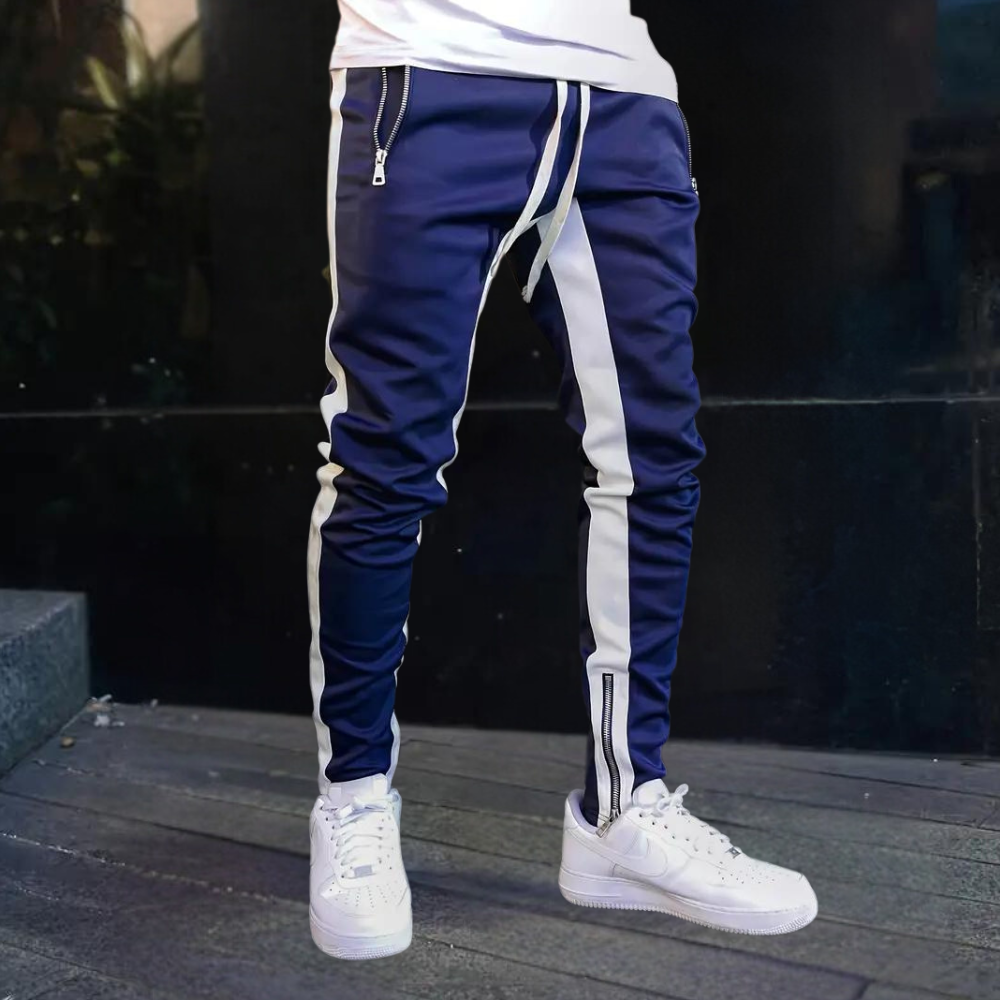 Comfortable men's athletic pants; slim fit joggers featuring bold contrast panels & adjustable zip cuffs.