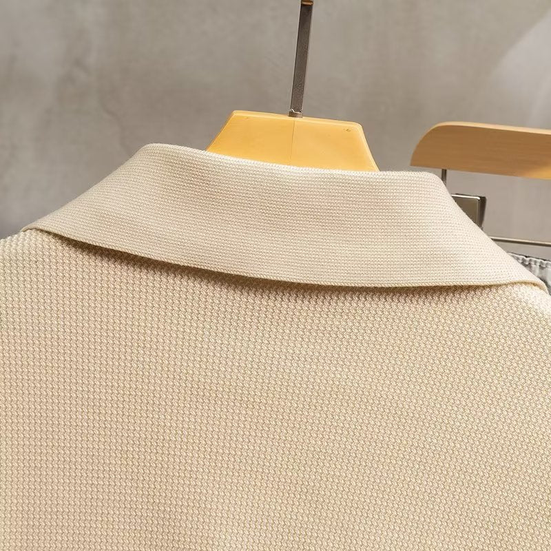 Close-up of men's ribbed long sleeve polo sweater, showcasing knit texture & quality.