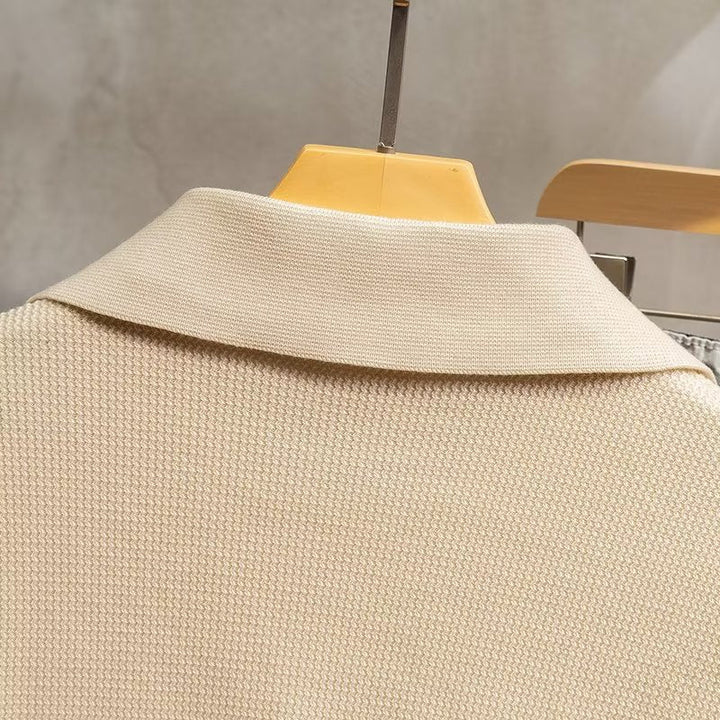 Close-up of men's ribbed long sleeve polo sweater, showcasing knit texture & quality.