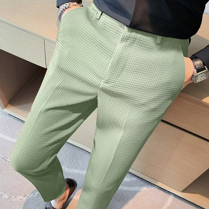 Men's textured slim fit dress trousers in a dark color, perfect for formal or casual chic outfits.