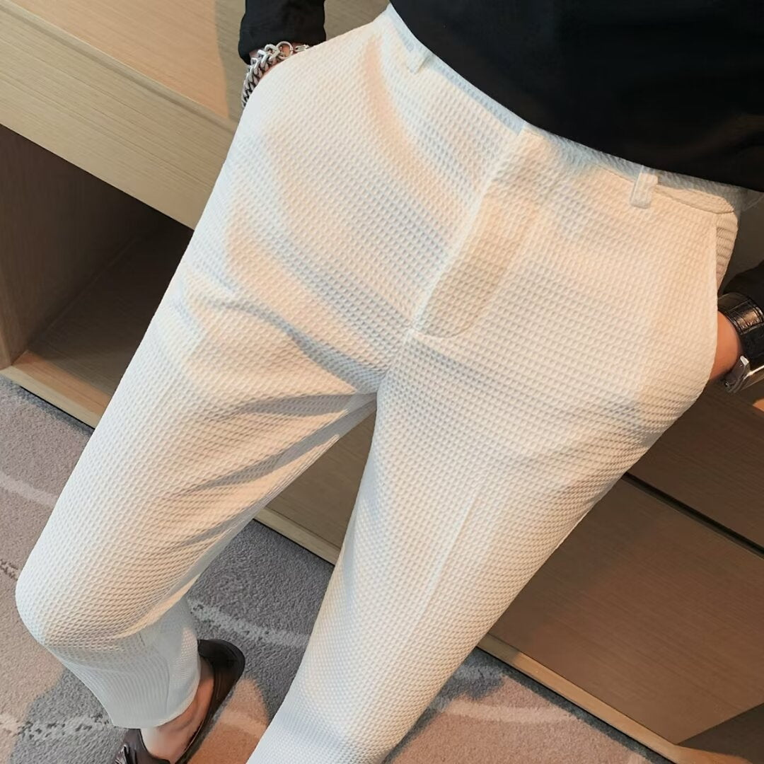 Close-up of men's slim fit dress trousers, showing the textured fabric detail for a sophisticated look.