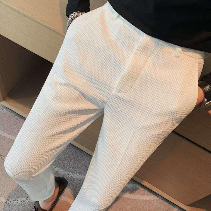 Close-up of men's slim fit dress trousers, showing the textured fabric detail for a sophisticated look.