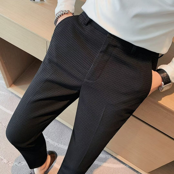 Detailed shot of the high-quality textured fabric on men's slim fit dress trousers, emphasizing craftsmanship.