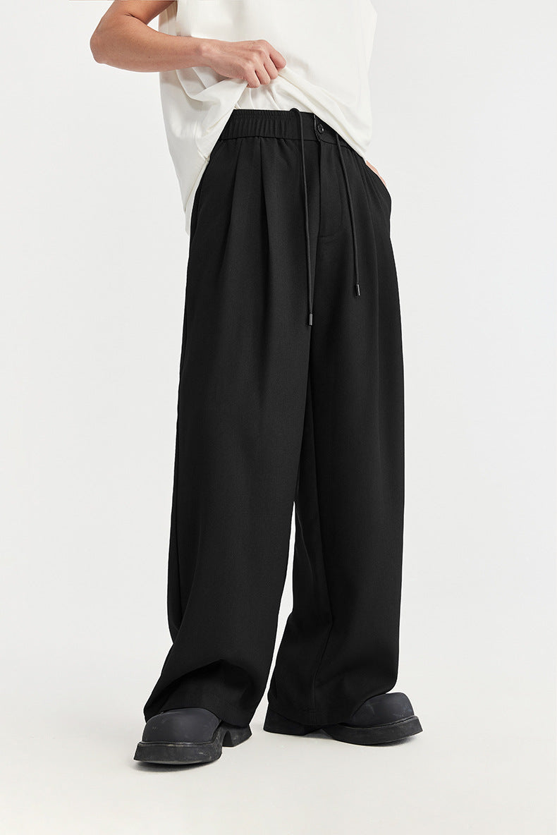 Loose fit men's wide leg pleated chino pants with an adjustable drawstring waist for relaxed comfort.