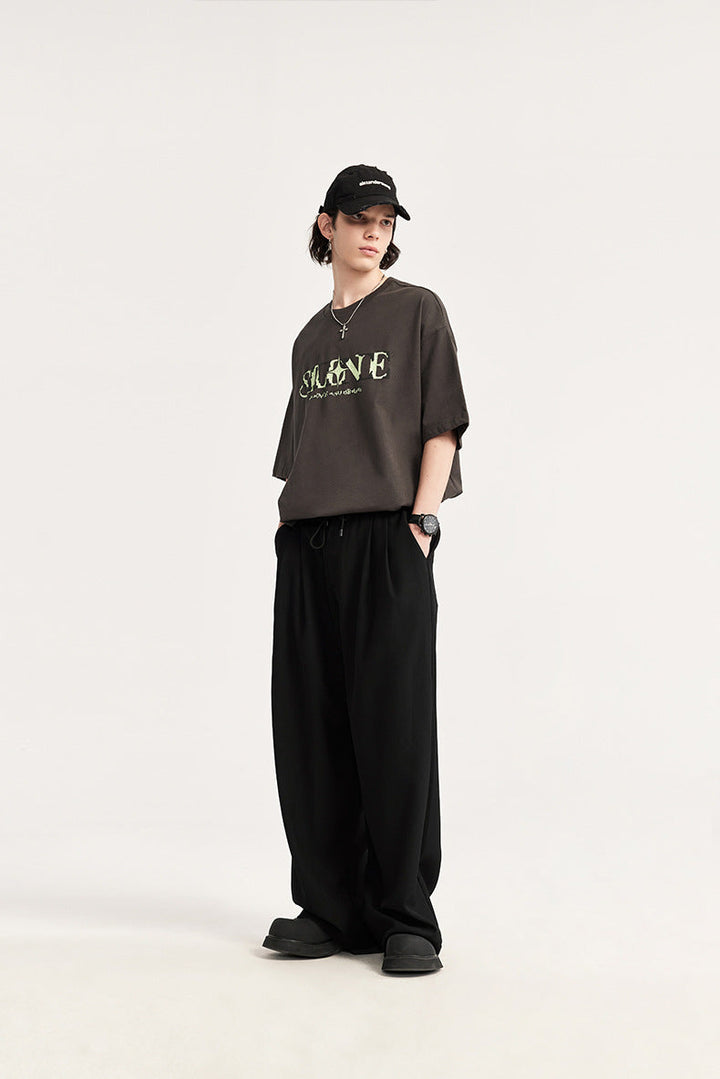 Comfortable men's wide leg drawstring chino trousers featuring elegant pleats & a relaxed fit.