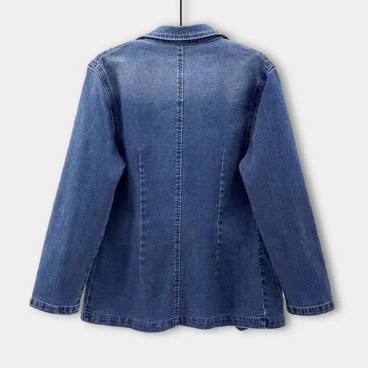 Close-up of a women's tailored fit denim blazer in blue, highlighting the fabric and fashion details.