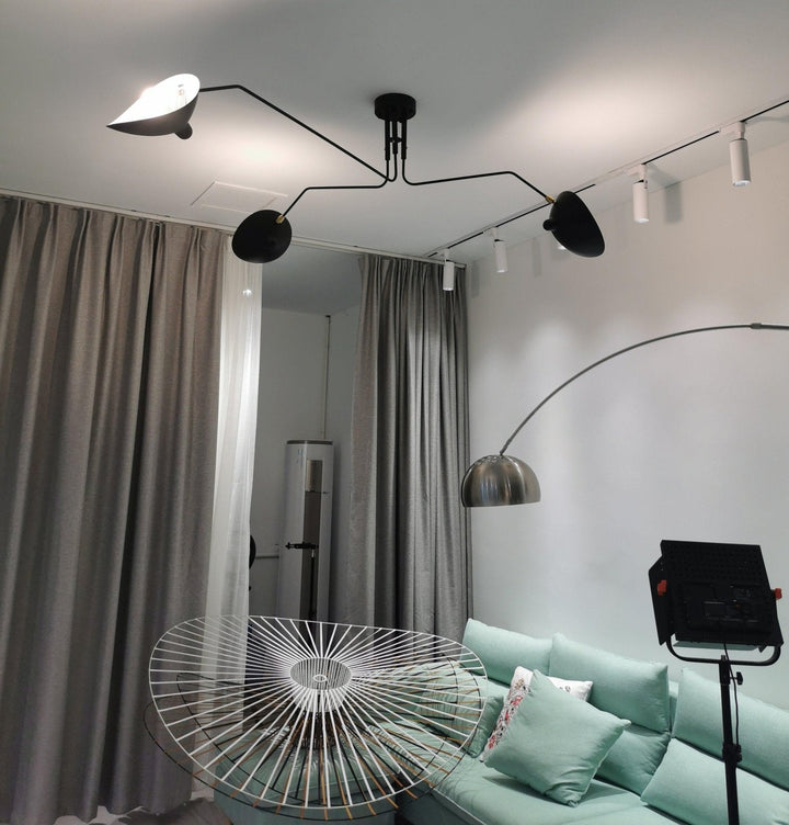 Multi-arm ceiling lamp with adjustable heads, enhancing a modern living room.