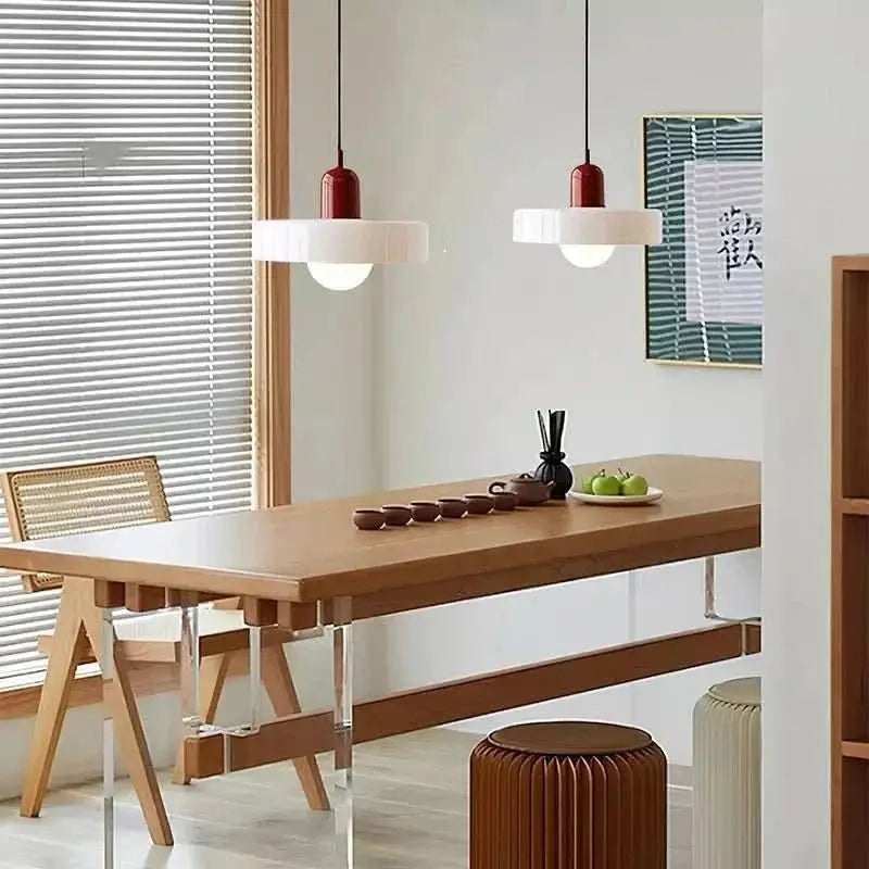Sleek modern colored glass pendant, elegant and adjustable for various room settings.